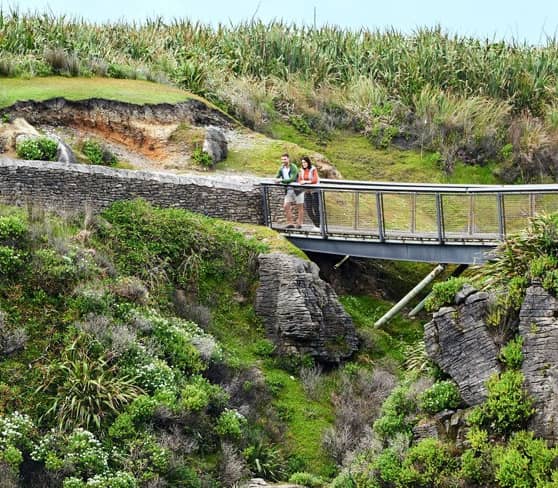 Tourists enjoy the view at Pancake Rocks, Punakaiki, New Zealand.