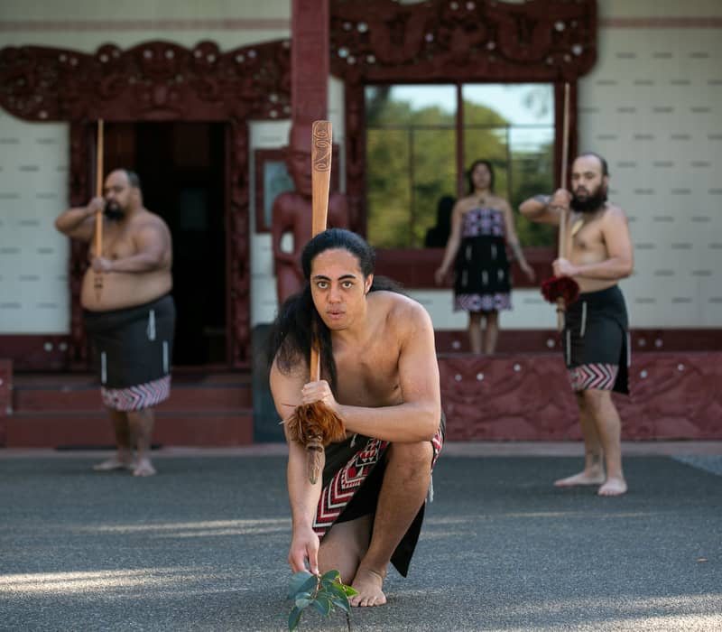 Maori performers in traditional clothing and tattoos dancing at Waitangi Treaty Grounds