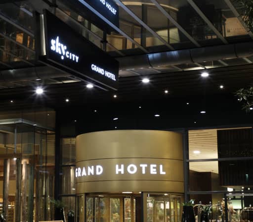 Night view of modern hotel entrance with illuminated SkyCity Grand Hotel sign and revolving door