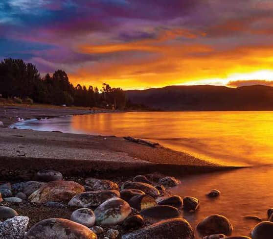 Stunning sunset over Lake Te Anau with vibrant sky reflections.