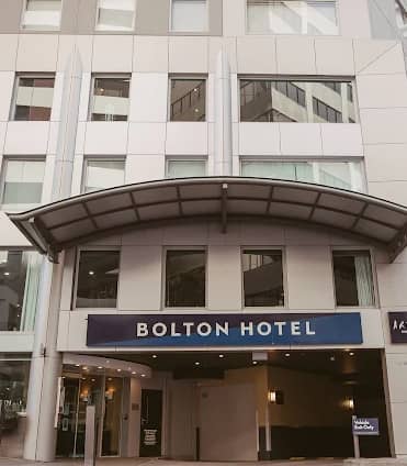 Front entrance of Bolton Hotel with signage and modern windows in an urban area.