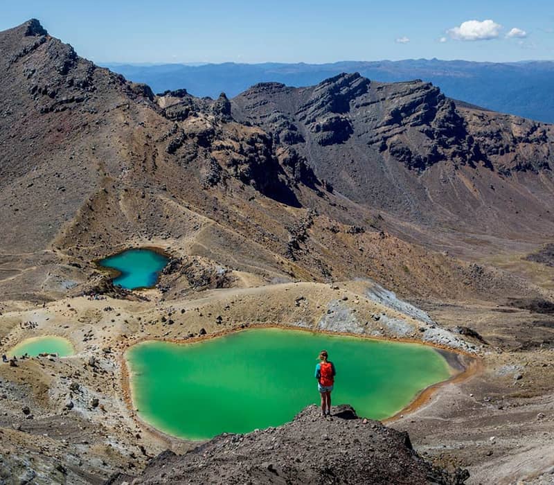 Hiker overlooks emerald lakes in Tongariro National Park, New Zealand.