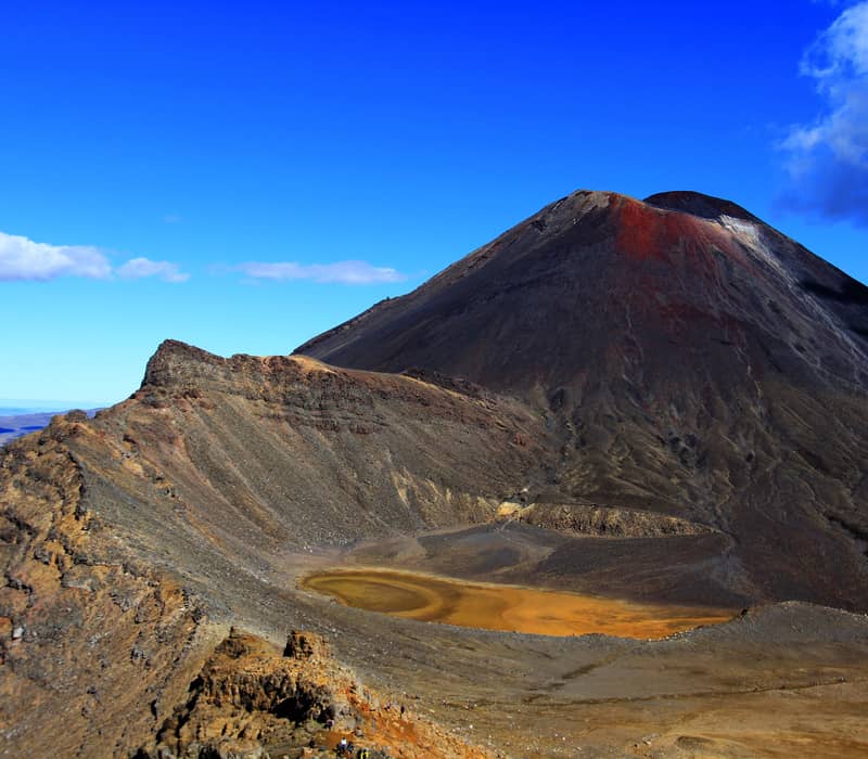 Mt Ngauruhoe volcano with orange crater lake under a clear blue sky