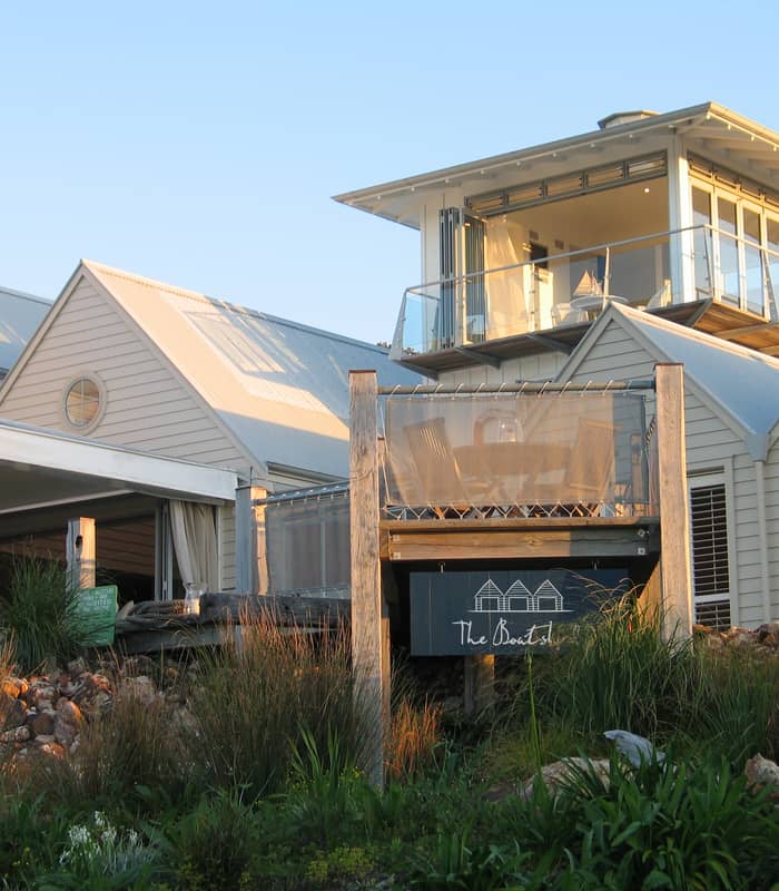 Bright bedroom with king bed, wooden floor, table lamps, and simple decorations.