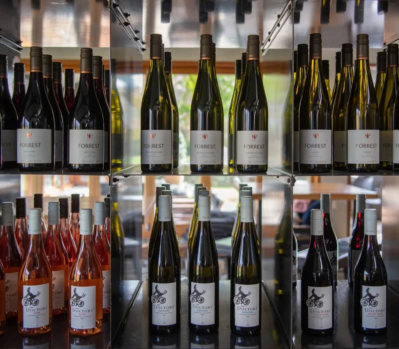 Various wine bottles with different labels arranged on shelves at a winery.