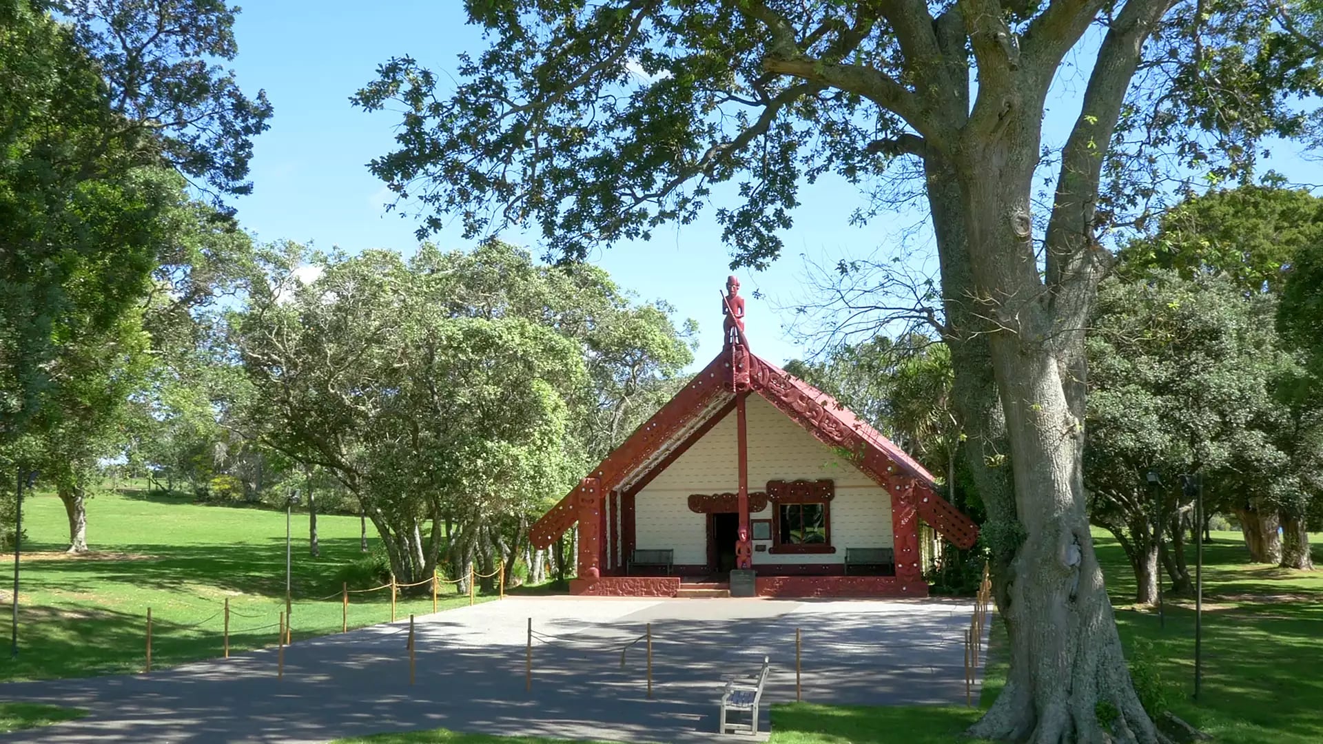 Maori meeting house Te Whare Runanga surrounded by trees and grass at Waitangi Treaty Grounds.