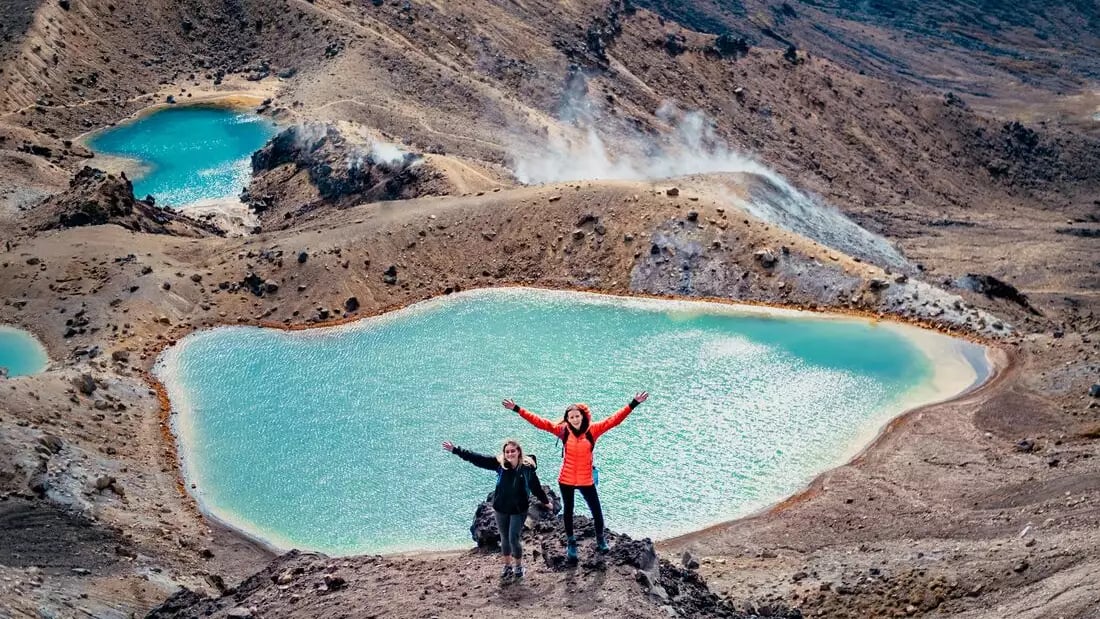 Hikers at Emerald Lakes in New Zealand's volcanic landscape.