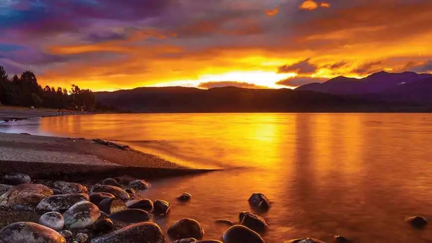 Stunning sunset over Lake Te Anau with vibrant sky reflections.
