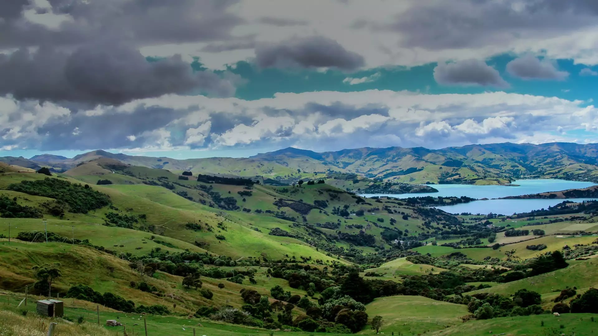 A Skyline View of Akaroa with Green Hills & Lakes