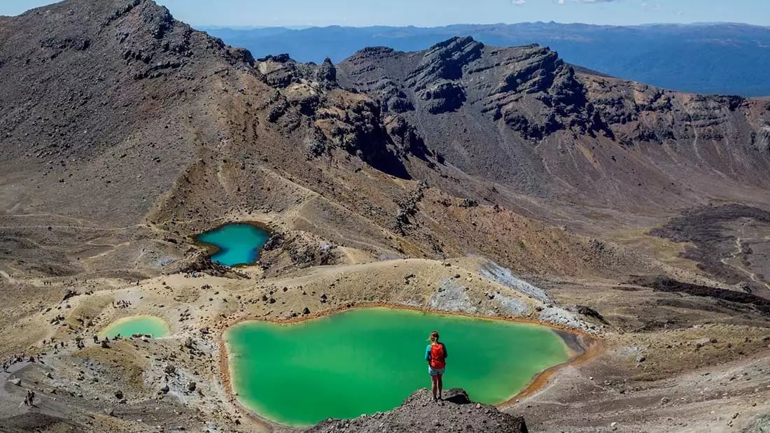Hiker overlooks emerald lakes in Tongariro National Park, New Zealand.