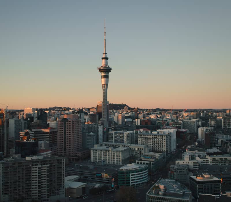 Auckland city skyline with the Sky Tower at sunset.
