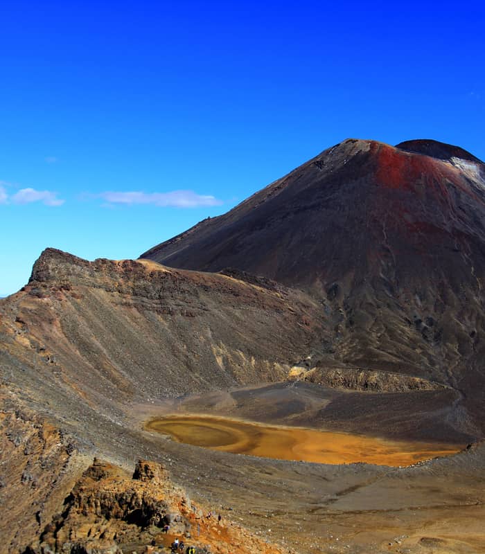 Mt Ngauruhoe volcano with orange crater lake under a clear blue sky Credit: New Zealand Fine Touring