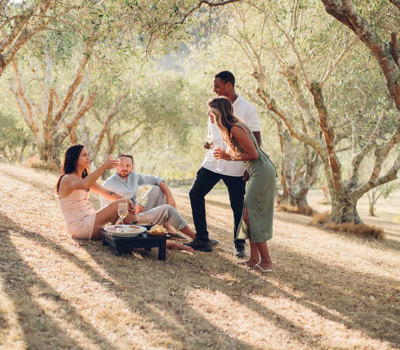 Friends enjoying wine together outdoors at Stonyridge Vineyard.