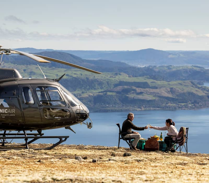 Couple having picnic ontop of mountain overlooking Lake Rotoiti with Volcanic Air.