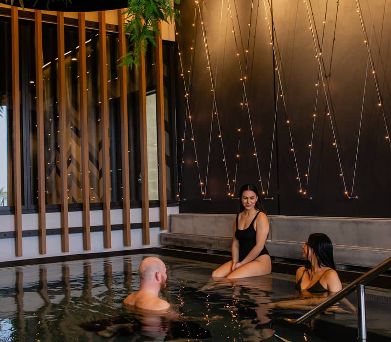 People relaxing in pool talking at Wai Ariki