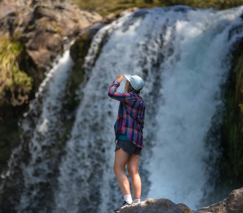 Woman standing at waterfalls.