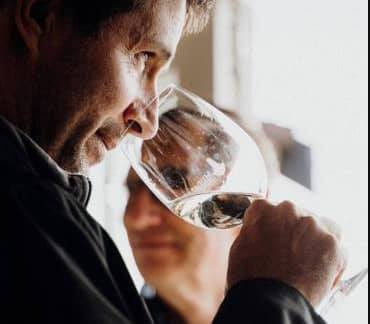 Man smelling wine in glass during tasting indoors