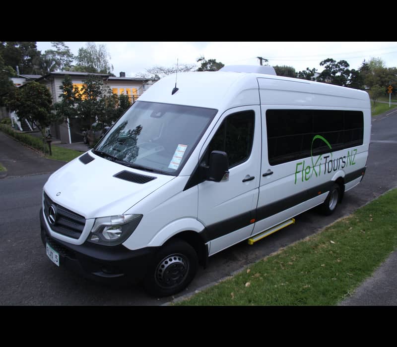 White FlexiToursNZ Mercedes van parked on suburban street at dusk