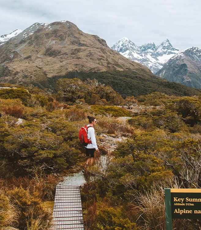 Hiker on alpine trail at Key Summit with mountains and snow in the background
