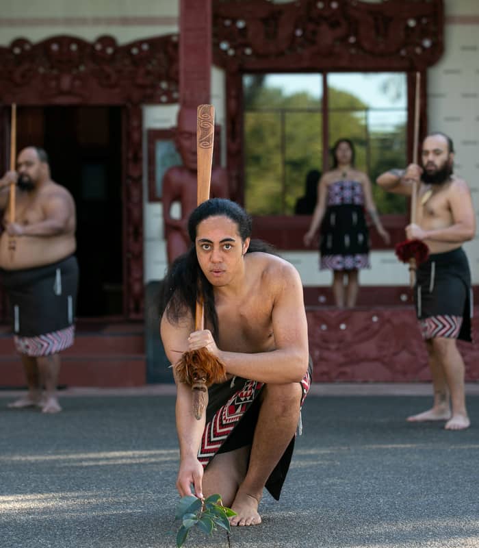 Maori performers in traditional clothing and tattoos dancing at Waitangi Treaty Grounds
